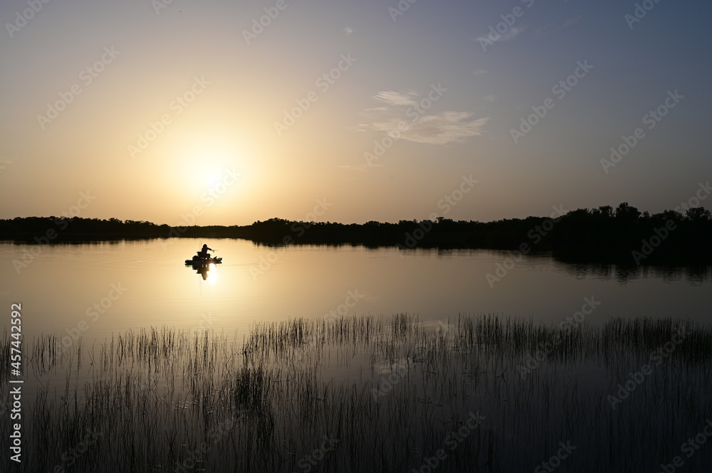 Colorful sunrise cloudscape reflected in calm water of Nine Mile Pond in Everglades National Park, Florida in summer.