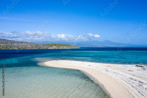 Aerial drone landscape of Menjangan island located at the northern western tip of Bali in Indonesia with white sand beach facing the volcanoes of Java