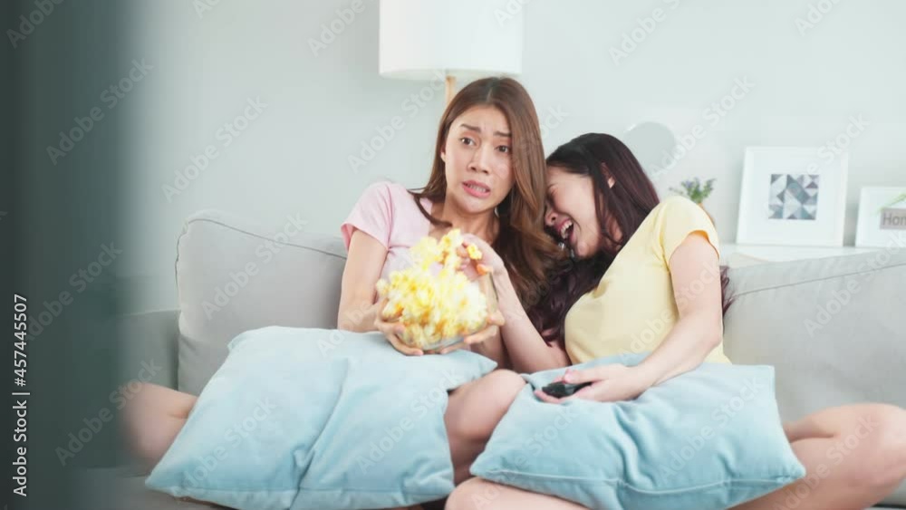 Asian young woman couple watch jump scare movie on television at home.
Asian young woman couple watch jump scare movie on television at home.