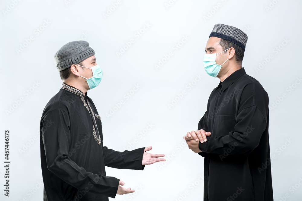 Two good looking Asian Muslim men standing, hello, greeting with a smiley face, on white background. Two good looking Asian Muslim men standing, hello, greeting with a smiley face, on white background.
