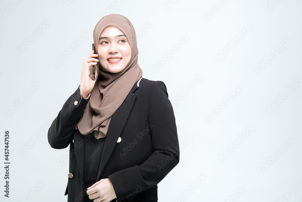 Office worker, Asian Muslim woman standing talking on a mobile phone with a happy face, on white background. Office worker, Asian Muslim woman standing talking on a mobile phone with a happy face, on white background.
