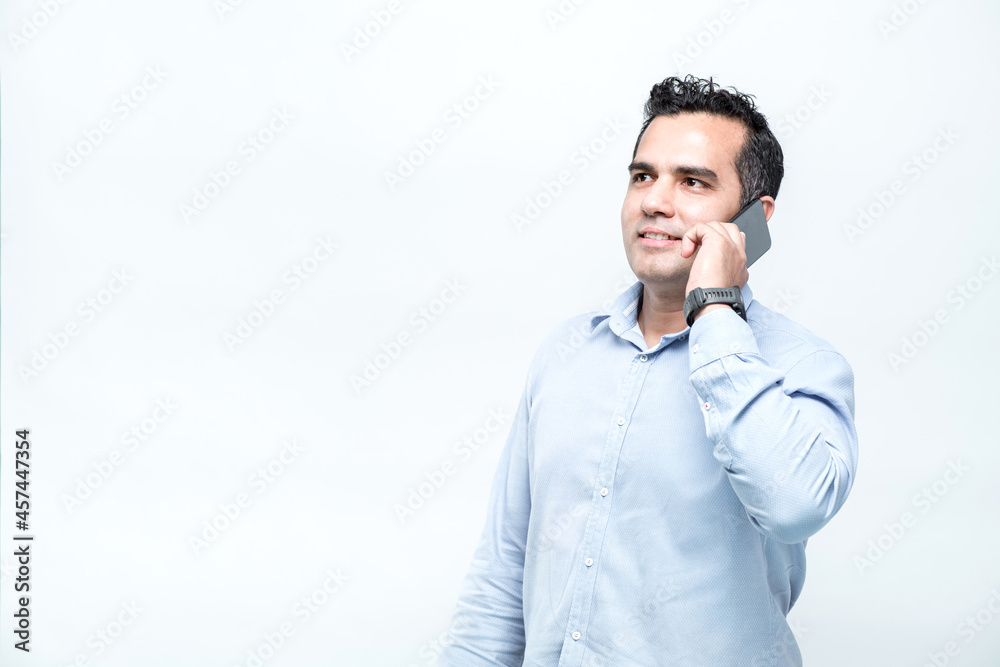 An Asian working man in an office suit is standing typing a chat on a mobile phone with a smiling face, on white background. An Asian working man in an office suit is standing typing a chat on a mobile phone with a smiling face, on white background.