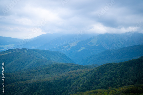 秋の紅葉が始まった栂池自然園の展望台までトレッキングしている風景 A view of trekking to the observatory of Tsugaike Nature Park, where the autumn leaves have started to change color. 