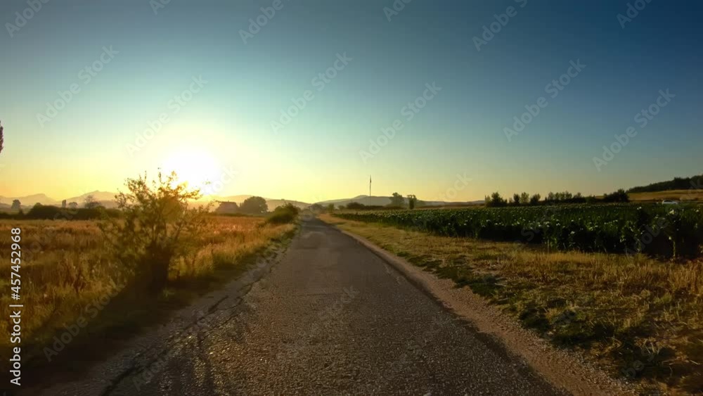 POV drive old narrow road, golden fields, remote mountains, beautiful morning sun POV drive old narrow road, golden fields, remote mountains, beautiful morning sun