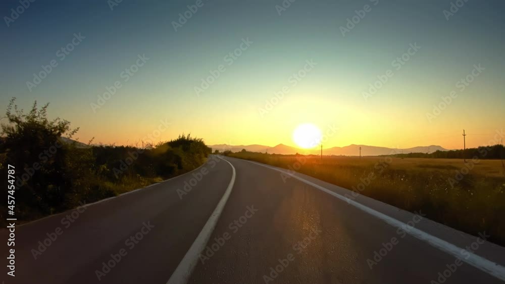 Vivid sunset sky, golden valley, POV car drive on asphalt road
