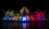 The colorful water fountain dancing in celebration festival refection color on water with dark night sky background