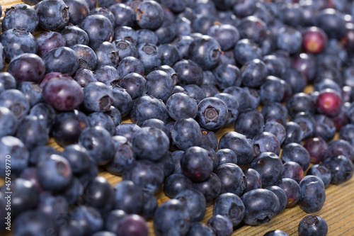 Heap of fresh blueberries scattered on wooden surface