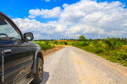 Country road in the cultivated land with turbine in background