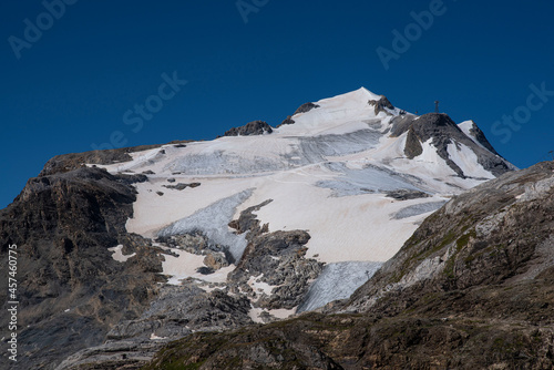 A summer mountain hiker on the summits in front of glaciers 