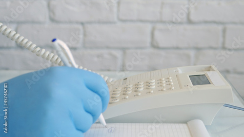 Image with Businessman Hands Wearing Protective Gloves Using Telephone