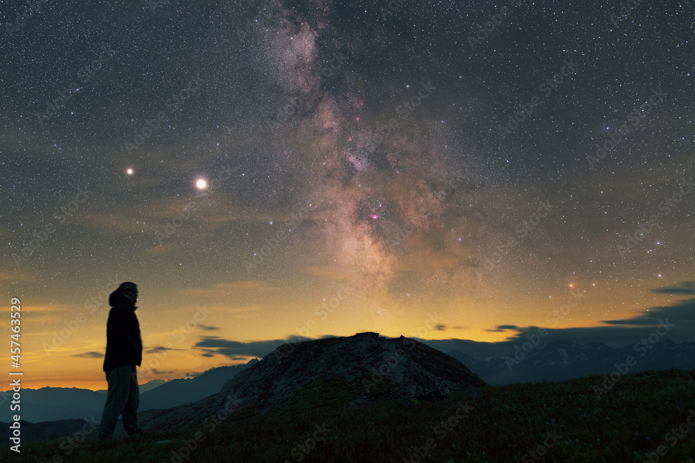Lone man watching Milky Way over Alps with Jupiter, Saturn and Magenta Nebulaes