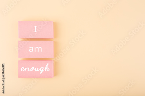 I am enough minimal concept on bright pastel beige background with copy space. Mental health and self love concept