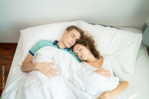 Couple sleep in morning on white bed cozy room