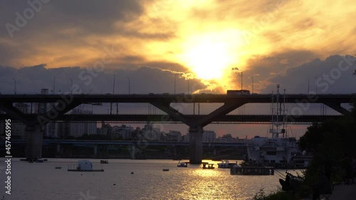 Golden sunset glows over the city of Seoul Korea with the Cheongdam vehicle and train rail bridge across the Han River photo