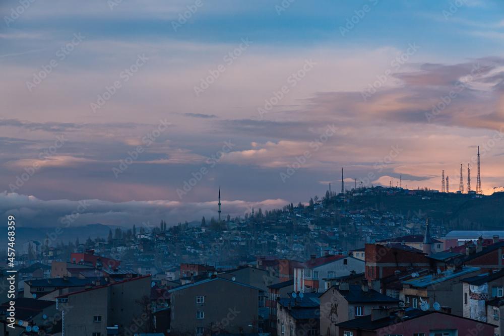 Obraz premium トルコ エルズルムのエルズルム城から見える丘に広がる街並みと夕焼けの空
