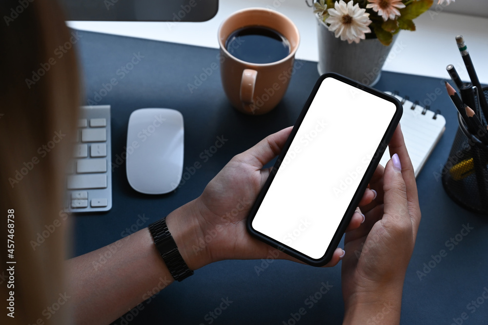 Young woman sitting at her workplace and using smart phone. Young woman sitting at her workplace and using smart phone.