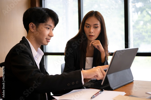 Smiling disabled male worker working with colleagues in modern office.