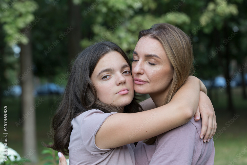 Mom and teenage daughter have fun on a walk in the park. Happy family concept Mom and teenage daughter have fun on a walk in the park. Happy family concept