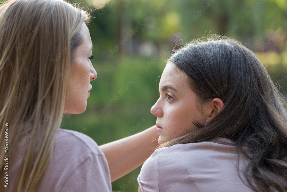 Mom and teenage daughter have fun on a walk in the park. Happy family concept Mom and teenage daughter have fun on a walk in the park. Happy family concept
