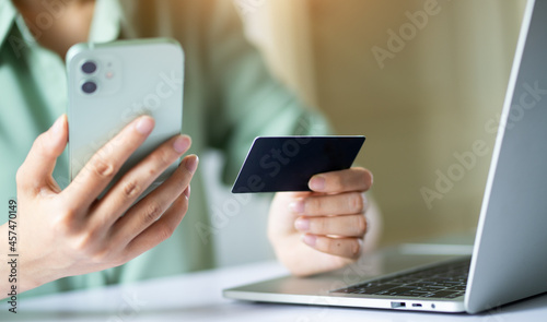 Asian woman using credit card to pay online
