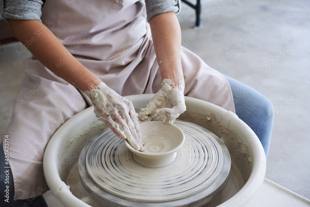 Master class in pottery workshop, woman making dish out of white clay