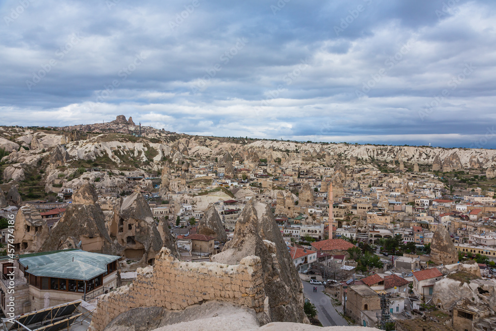 トルコ　カッパドキアのギョレメの街並みと街中にある洞窟住居と遠くに見えるウチヒサール城