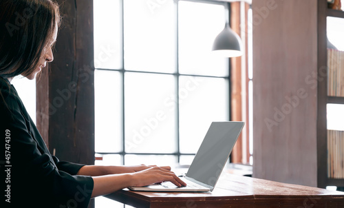 Woman working on laptop in vintage style room.