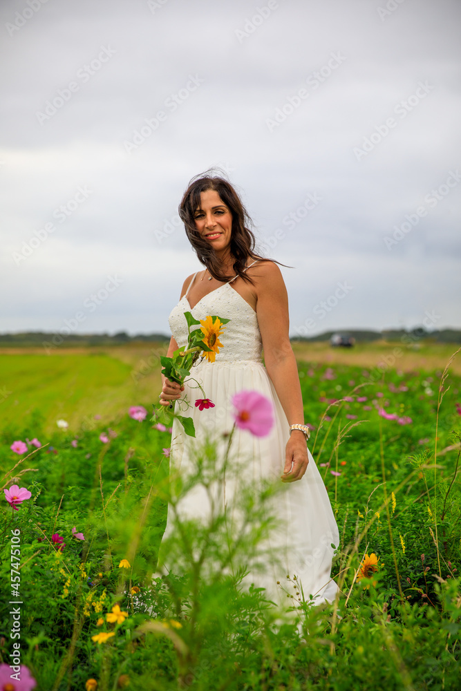 Junge hübsche Frau im Brautkleid in einer Blumenwiese Junge hübsche Frau im Brautkleid in einer Blumenwiese