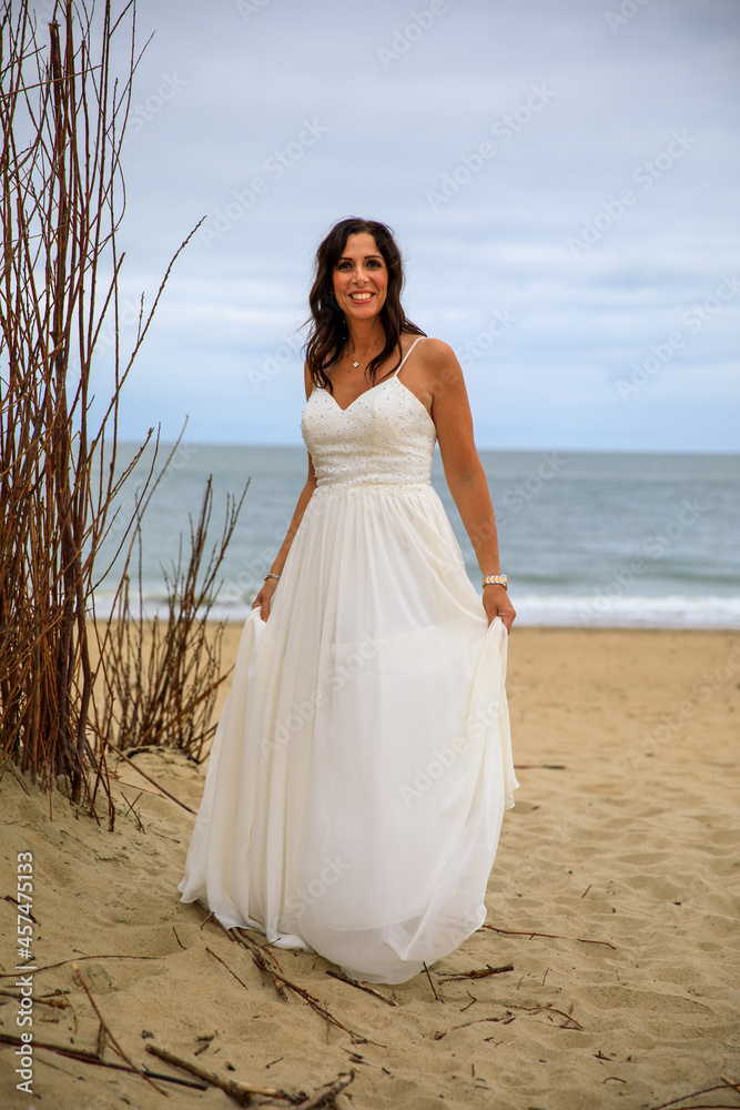 Junge schöne Braut im Hochzeitskleid am Meer Junge schöne Braut im Hochzeitskleid am Meer