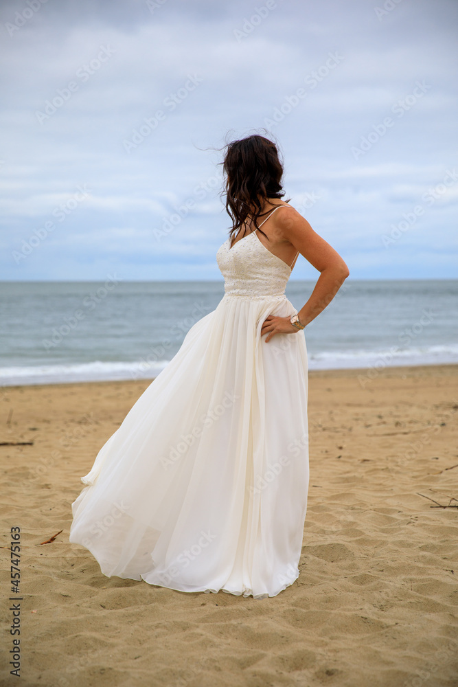 Junge schöne Braut im Hochzeitskleid am Meer