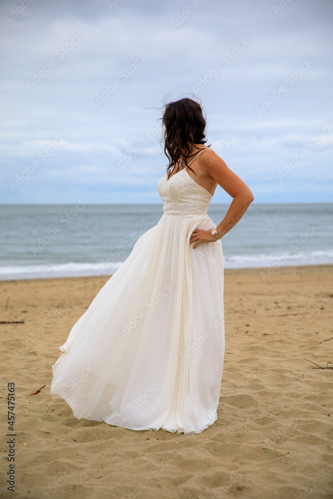 Junge schöne Braut im Hochzeitskleid am Meer Junge schöne Braut im Hochzeitskleid am Meer