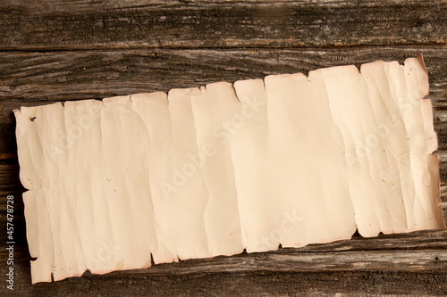 vintage crumpled scroll of paper with place for text on a rough wooden table. Empty background