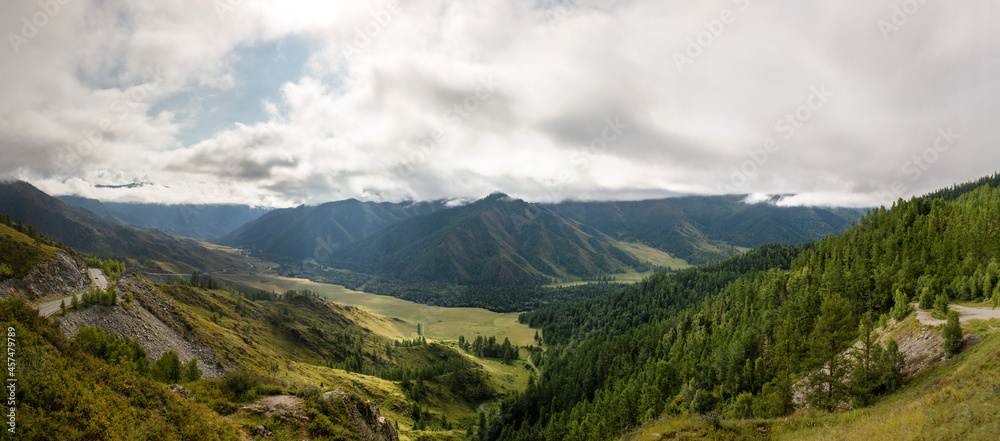 view from the top of the mountain pass to the valley drenched in the sun breaking through the clouds on a warm summer day, mountains, road
view from the top of the mountain pass to the valley drenched in the sun breaking through the clouds on a warm summer day, mountains, road
