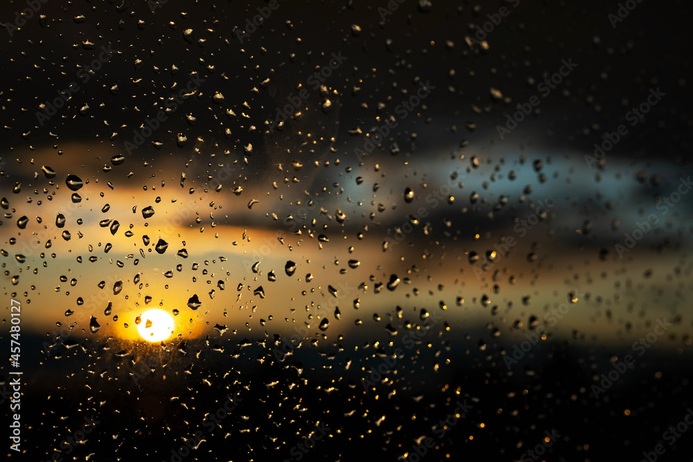 Window glass after rain with water drops.  Background of stormy sunset sky.