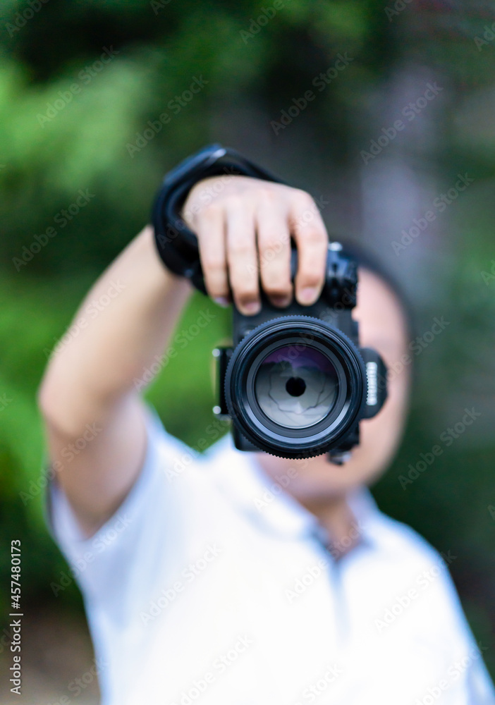 Fototapeta premium Asian man holds the Medium Format Camera in his hand and focus to shoot in front of him.
