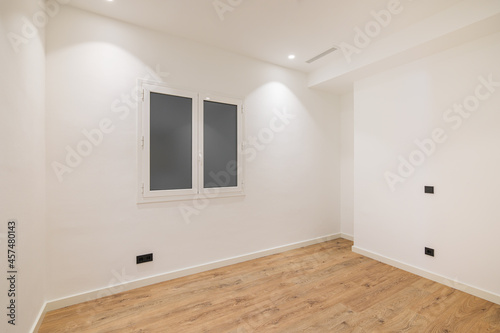 Empty clean room after renovation with white walls  window and wooden floor