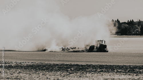 tractor on the field with lots of dust © @foxfotoco