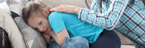 Mom stroking back and comforting little girl at home