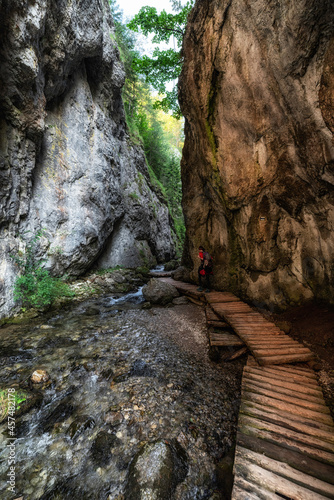 Hiker on walking trail in rocky canyon. Prosiecka valley in Slovakia photo