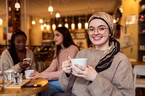 Portrait of young woman drinking coffee in cafes with her friends.