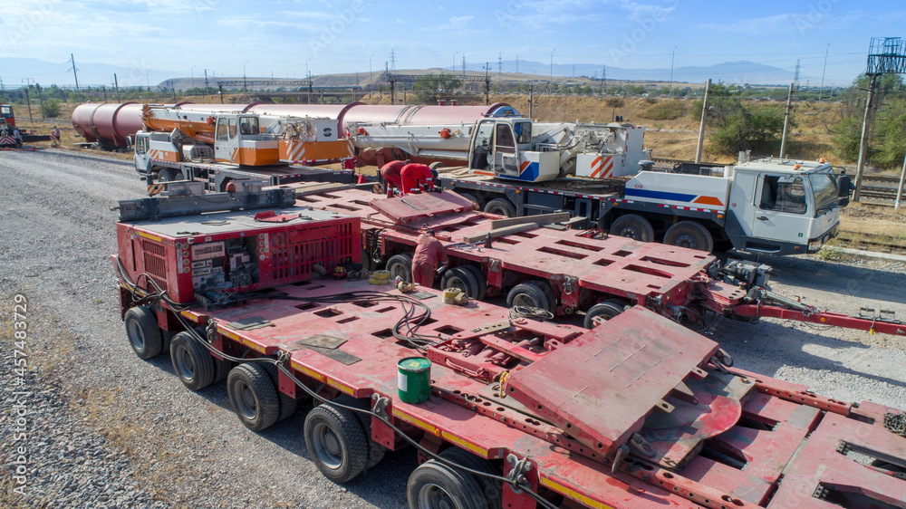 Cargo transportation. Transportation of oversized cargo. Mechanics prepare a trailer for transportation of oversized cargo