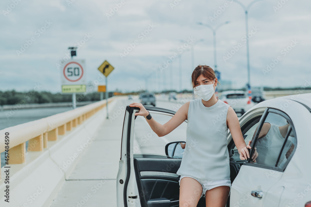 Asian woman   wearing protective face mask protection safety before getting out of the car during coronavirus covid-19 outdoor curfew pandemic