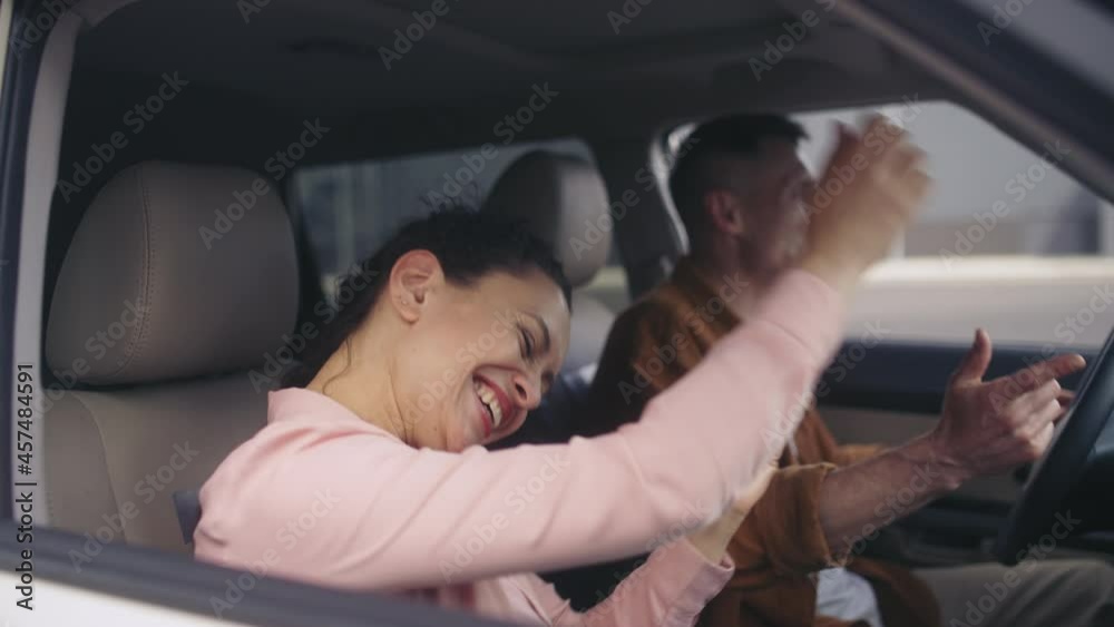 Cheerful husband and wife dancing, celebrating purchase of the car, success