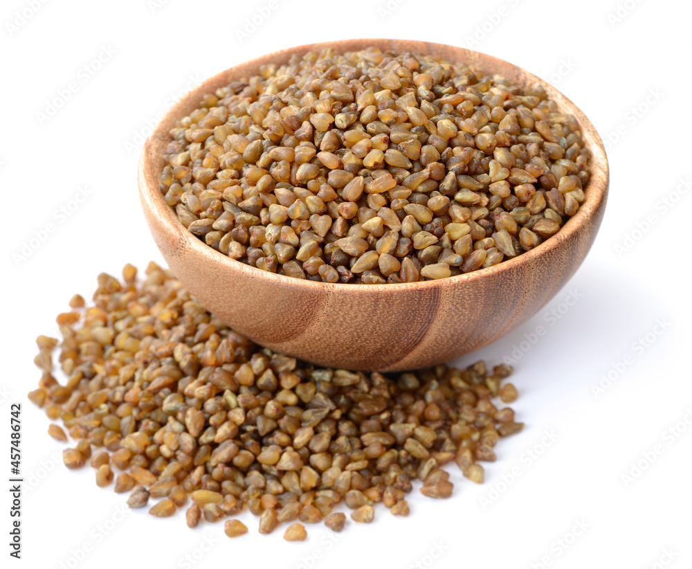 uncooked bitter buckwheat in the wooden bowl, isolated on the white background uncooked bitter buckwheat in the wooden bowl, isolated on the white background