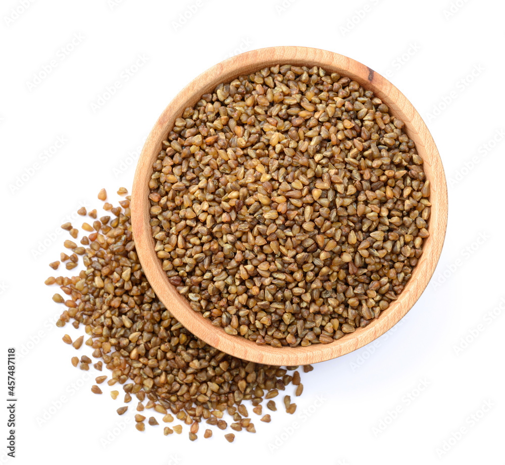uncooked buckwheat in the wooden plate, isolated on the white background, top view uncooked buckwheat in the wooden plate, isolated on the white background, top view