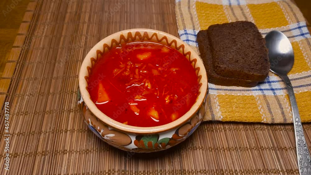 Freshly prepared hot steaming red beetroot borscht in clay bowl
