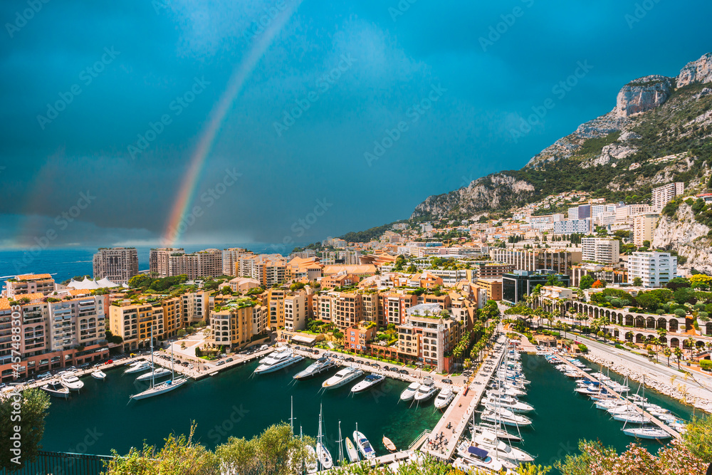 Yachts moored near city Pier, Jetty In Sunny Summer Day. Monaco, Monte Carlo architecture. Altered Sky With rainbow