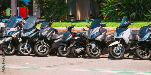 Motorbike, motorcycle scooters parked in row in city street