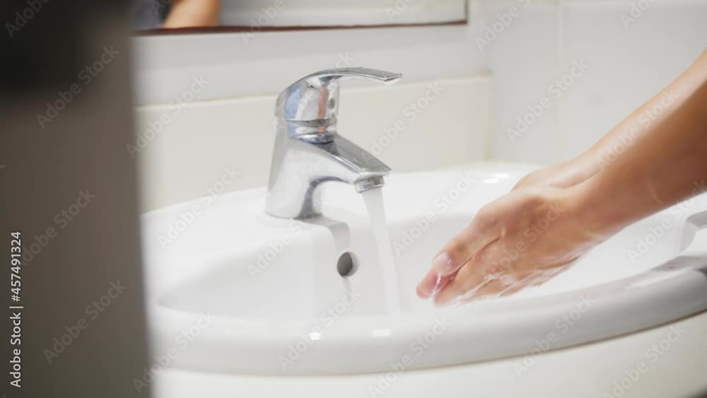 Person washing hands with foam soap and clean water. Body care concept. Person washing hands with foam soap and clean water. Body care concept.