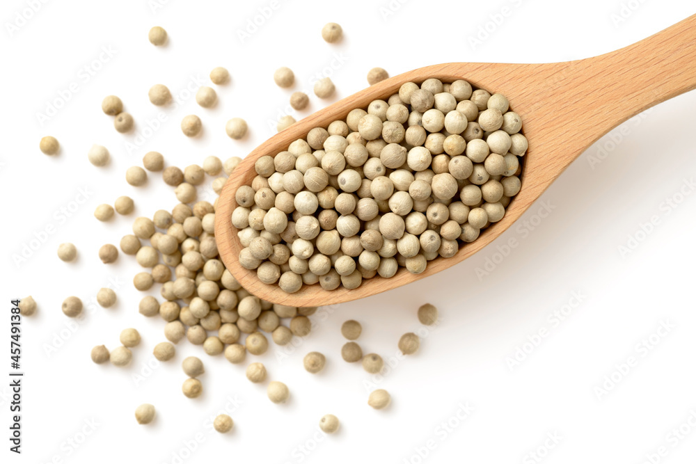 white peppercorns in the wooden spoon, isolated on white, top view